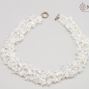May include: A white opal gemstone necklace with a silver clasp. The necklace is made of multiple strands of small, irregular shaped opal stones.
