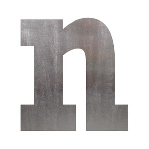 May include: A silver metal letter n with a textured surface.