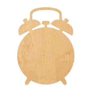 May include: A flat, light-colored wooden cutout shaped like a classic twin-bell alarm clock. The object features a circular main body, two bell-shaped protrusions at the top, a central hammer, a handle, and two small feet at the bottom base.