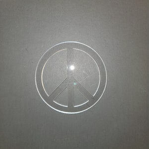 May include: A white peace sign cutout on a gray background.