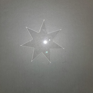 May include: A clear plastic eight-pointed star shape.