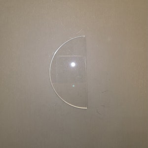 May include: A clear plastic half-circle shape.