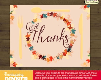 May include: Printable Thanksgiving dinner placemats featuring a wreath of autumn leaves with the text "Give Thanks". The placemats are designed for a Thanksgiving dinner and include a blank page for younger guests to draw on.