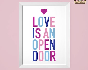 Puede incluir: Una impresión enmarcada en blanco con el texto "LOVE IS AN OPEN DOOR" en letras de colores. Las letras son de color rosa, azul, morado y azul oscuro. Un pequeño corazón rosa está en la parte superior de la impresión.