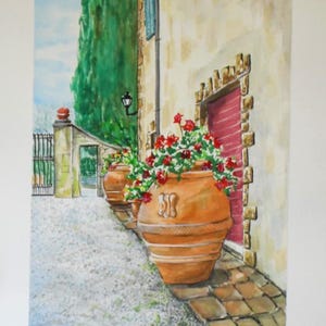 May include: Watercolour painting of a European street scene. Two large terracotta pots overflowing with red flowers sit in front of a building with a red door. A green tree and a wrought iron gate are visible.