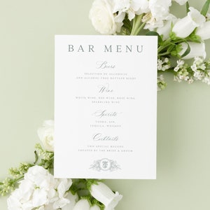 May include: A white bar menu card with the text "BAR MENU" in a grey font. The menu lists the different types of drinks available, including beers, wine, spirits, and cocktails. The card is decorated with a floral design.