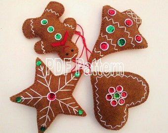 May include: Four felt Christmas ornaments in the shape of a gingerbread man, a star, a heart, and a bell. The ornaments are brown with white stitching and decorated with red and green sequins.