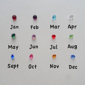 May include: A chart of colored gemstones representing the months of the year. January is red, February is purple, March is blue, April is white, May is green, June is pink, July is red, August is green, September is blue, October is pink, November is orange, and December is blue.