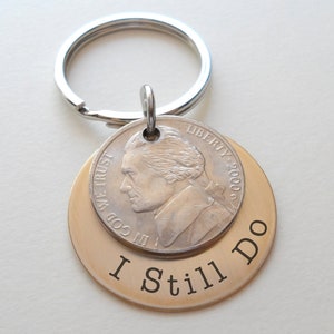 May include: A silver key chain with a gold-colored disc that says "I Still Do" and a silver US nickel with the year 2000.