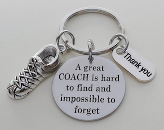 May include: Silver-toned keychain featuring a running shoe charm, a round charm with the text "A great COACH is hard to find and impossible to forget," and a tag that says "Thank you."