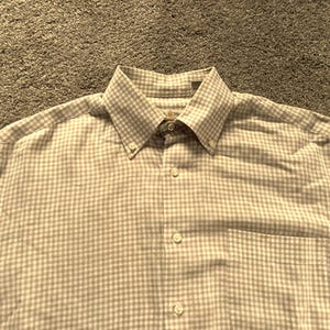 May include: A white and beige gingham button-down shirt with a pocket on the left side.