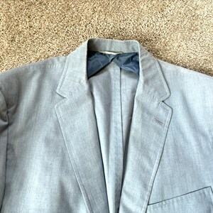 Könnte beinhalten: Ein hellblauer Blazer mit einem einzigen Knopfverschluss und einer Tasche auf der linken Seite.