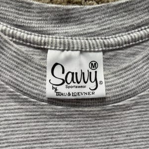 May include: Gray striped t-shirt with a white tag that says "Savvy Sportswear by Trau & Loevner" and has a size "M" label.