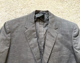 May include: A grey blazer with a single button closure and a pocket on the left side.