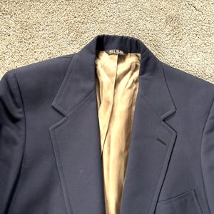 May include: A navy blue blazer with a brown lining and the label "Bill Blass" on the inside collar.