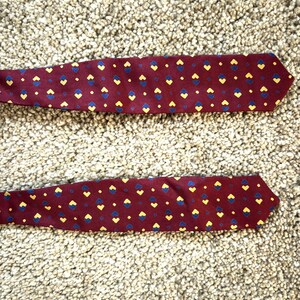 May include: Two red silk ties with a pattern of yellow and blue hearts.