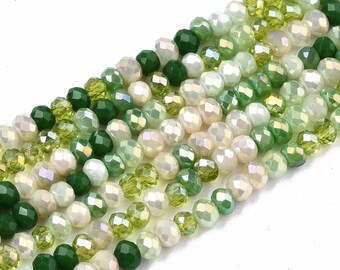 Peut inclure: Un brin de perles de verre facettées dans des tons de vert et de blanc. Les perles sont disposées en dégradé, avec les perles vert foncé à une extrémité et les perles blanc clair à l'autre.