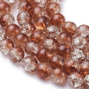 May include: A strand of brown glass beads with a clear, crackled finish. The beads are round and have a translucent appearance.
