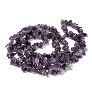 Könnte beinhalten: Eine Halskette aus Amethyst-Chip-Perlen. Die Perlen sind eine Mischung aus lila und durchscheinenden Farben. Die Halskette wird auf weißem Hintergrund präsentiert.