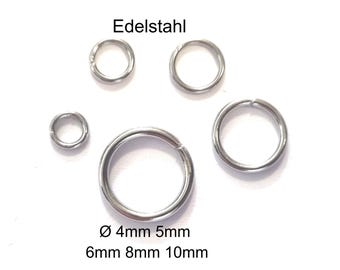 Könnte beinhalten: Eine Auswahl an Edelstahl-Sprungringen in verschiedenen Größen, von 4 mm bis 10 mm Durchmesser. Die Ringe sind auf weißem Hintergrund angeordnet, mit dem Wort "Edelstahl" darüber.