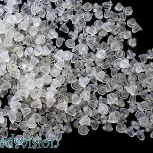 Può includere: Una grande quantità di chiusure per orecchini in plastica trasparente. Le chiusure sono piccole e hanno una parte superiore arrotondata e una parte inferiore piatta.