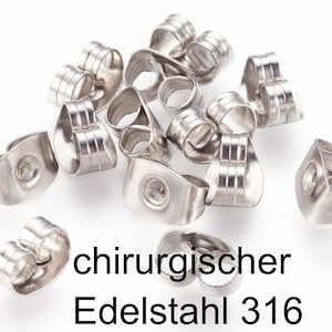 Könnte beinhalten: Nahaufnahme einer Reihe silberner Ohrringverschlüsse. Die Verschlüsse sind aus chirurgischem Stahl 316.