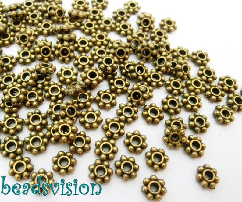 Daisy Spacer Metallperlen rund 6mm Farbe bronze antik S268 Bild 1