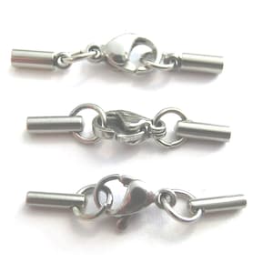 Könnte beinhalten: Drei silberfarbene Metallverschlüsse mit Endkappen für die Schmuckherstellung. Jeder Verschluss hat einen federbelasteten Verschluss und zwei Endkappen.