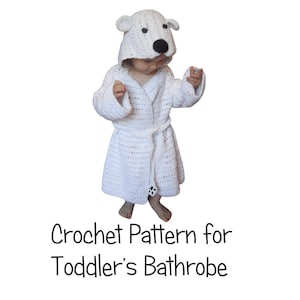 May include: White crocheted hooded bathrobe with a polar bear face on the hood. The bathrobe has a tie belt and is designed for a toddler.