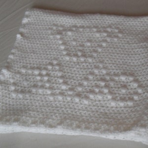 May include: White crocheted baby blanket with a diamond pattern.
