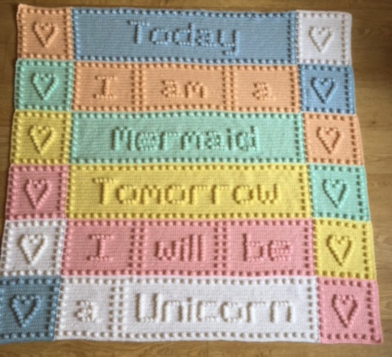 May include: A colorful crocheted baby blanket with the text "Today I am a mermaid tomorrow I will be a unicorn".