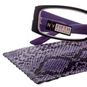 Op de afbeelding: Zwarte rechthoekige leesbril met paarse pootjes en een paars en zwart slangenhuidpatroon etui. De bril heeft een +1,25 vergroting en staat "NY Fifth Avenue" op de zijkant.