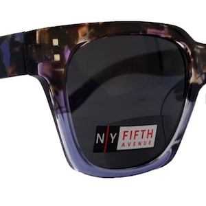 Könnte beinhalten: Violette und schwarze Schildpatt-Sonnenbrille mit dunklen Gläsern. Die Sonnenbrille trägt ein Etikett mit der Aufschrift "NY FIFTH AVENU".