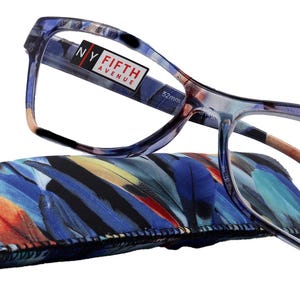 May include: Blue and purple reading glasses with a feather patterned case. The glasses have a black and red "NY Fifth Avenue" label on the right temple. The case has a colourful feather pattern with blue, orange, red, and white feathers.