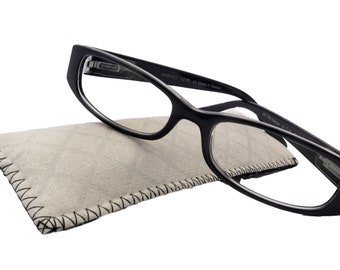Könnte beinhalten: Schwarze rechteckige Brille mit einem grauen Stoffetui. Die Brille hat einen schwarzen Rahmen und klare Gläser. Das Etui hat einen schwarzen, genähten Rand.