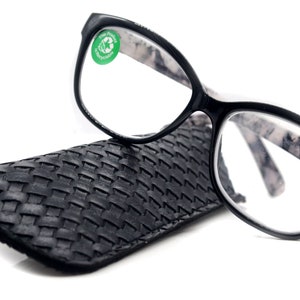 May include: Black reading glasses with a marble pattern on the arms and a black woven case. The glasses have a +2.50 magnification.