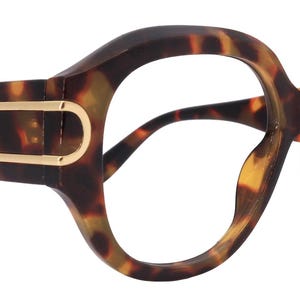 May include: Oversized tortoiseshell eyeglasses. The frames are a mix of dark brown and amber, with gold-coloured detailing. The glasses have a distinctive, rounded shape. The frame width is approximately 15 cm.