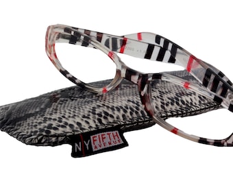 May include: Clear reading glasses with a black and red striped pattern on the frame. The glasses are folded and resting on a black and white snakeskin patterned case with a black tag that reads "NY FIFTH AVENUE".