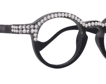 Puede incluir: Gafas redondas negras con lentes transparentes y una fila de diamantes de imitación alrededor del marco.