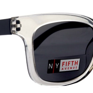 Könnte beinhalten: Sonnenbrille mit klarem Kunststoffgestell, schwarzen Bügeln und dunkelgrauen Gläsern. Die Sonnenbrille trägt den Schriftzug "NY FIFTH AVENUE" auf dem rechten Glas.