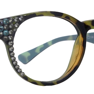 Könnte beinhalten: Leopardenmuster-Brille mit runden Gläsern und Strasssteinen an den Bügeln. Die Gläser sind klar.