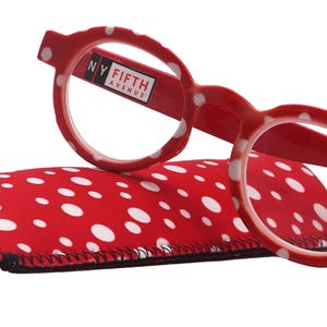 May include: Red and white polka dot reading glasses with a matching polka dot case. The glasses have a clear lens and the case has a black trim.