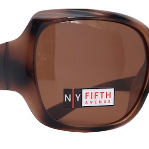 May include: Brown tortoise shell sunglasses with brown lenses. The sunglasses have a square shape and a thick frame. The brand name "NY Fifth Avenue" is printed on the right lens.