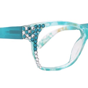 May include: Teal blue cat-eye glasses with clear lenses and rhinestones around the frames.