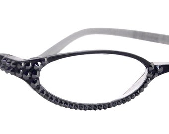 Puede incluir: Gafas ovaladas negras con un borde de pedrería alrededor de las lentes.