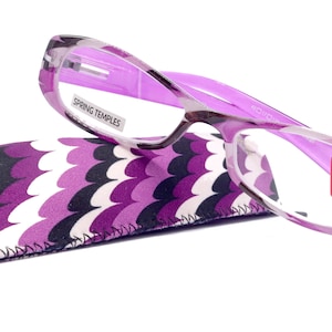 May include: A pair of purple reading glasses with a matching patterned case. The glasses have a rectangular frame with the text "SPRING TEMPLES" on the arm. The lenses have a red sticker with the text "+2.75 14".