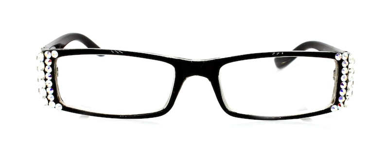 May include: Black rectangular eyeglasses with clear lenses. The frames are adorned with sparkling, iridescent rhinestones along the outer edges. The temples are black and curve gently. The glasses are set against a white background.