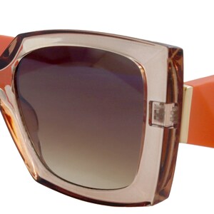 Puede incluir: Gafas de sol cuadradas de gran tama&ntilde;o con un marco grueso de color marr&oacute;n y patillas naranjas.