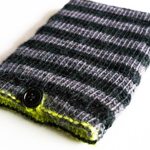 Puede incluir: Una funda de teléfono de punto a rayas negras y grises con un borde verde brillante y un botón negro.