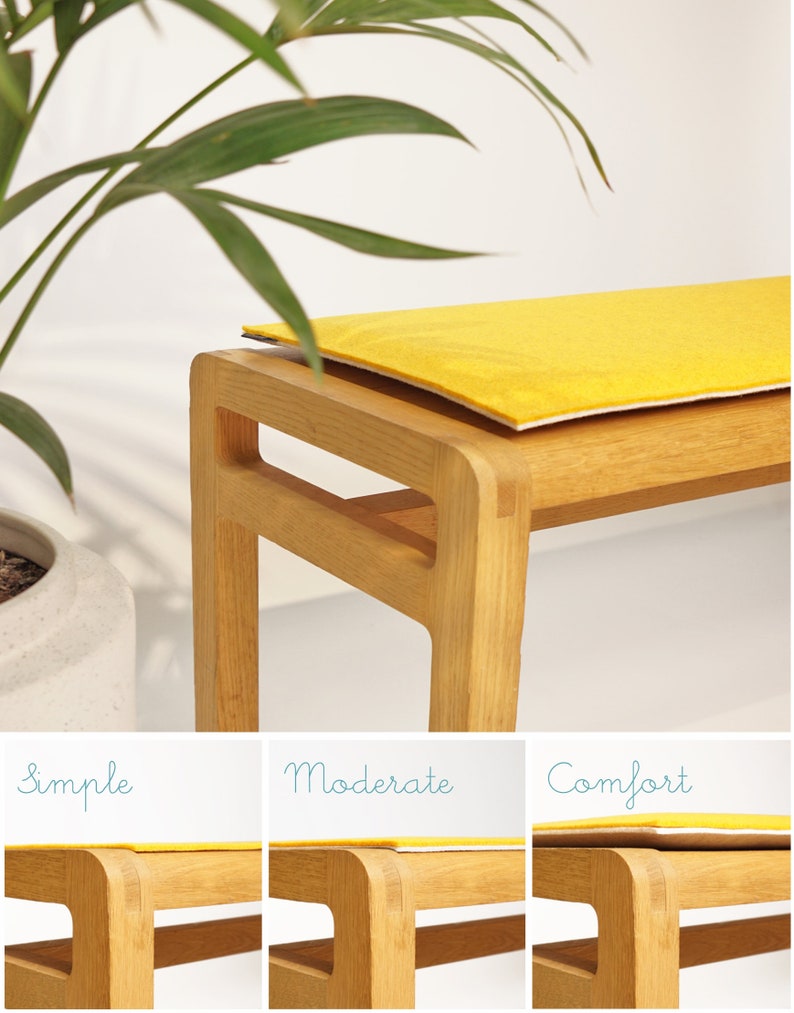 Puede incluir: Un banco de madera con un coj&iacute;n amarillo brillante. El banco es de madera clara y tiene un dise&ntilde;o simple y moderno. El coj&iacute;n es rectangular y parece estar hecho de un material suave. El banco est&aacute; colocado frente a un fondo blanco.